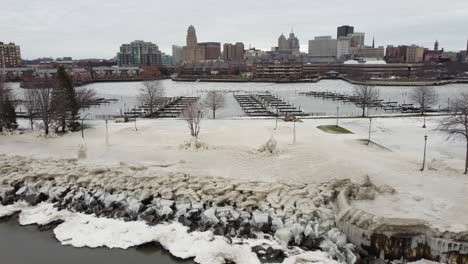 Slow-motion-aerial-from-a-snow-filled-park-near-a-big-city