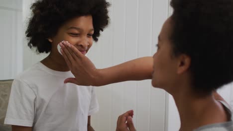 Mixed-race-mother-and-daughter-having-fun-in-bathroom