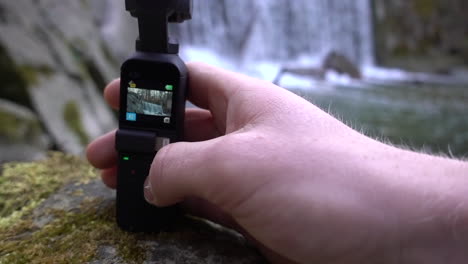 a filmmaker is setting its dji osmo pocket camera next to a small swiss alps river