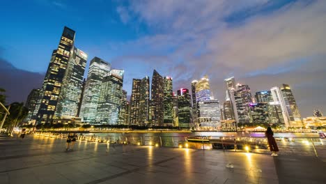 time-lapse of people walk in financial business district at marina bay singapore city with skyscraper tower buildings. pedestrian transportation, asia travel landmark, or asian city life concept. zoom out
