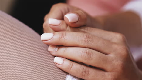 woman-in-white-stockings-holds-hands-with-elegant-manicure