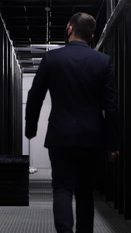 businessman walking in a dark server room