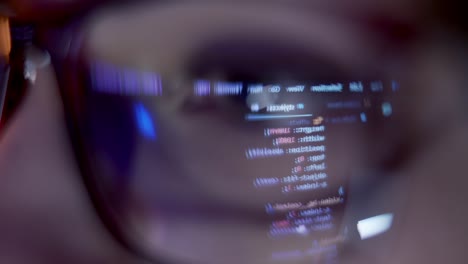 At night a young girl in glasses prints on a laptop sitting on the couch
