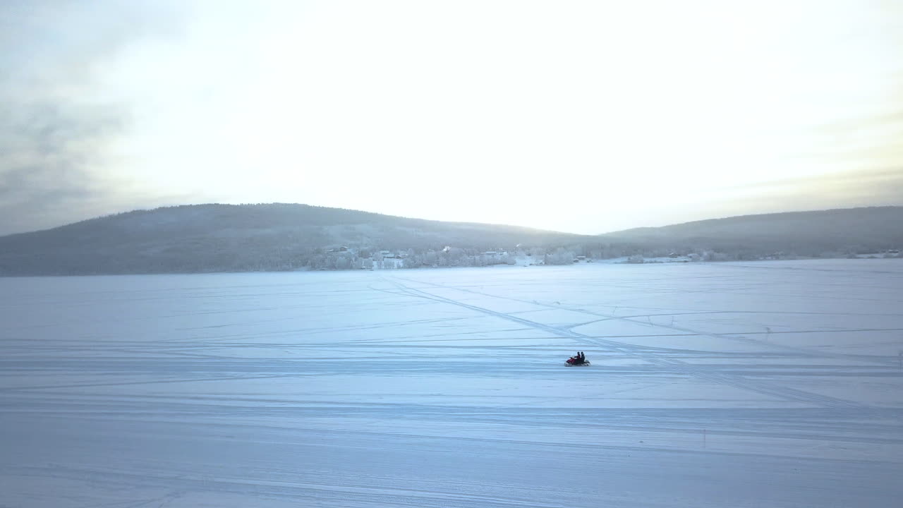 스웨덴 키루나(kiruna)의 산 전망을 감상할 수 있는 설원에서 스노우 모빌을 타는 사람