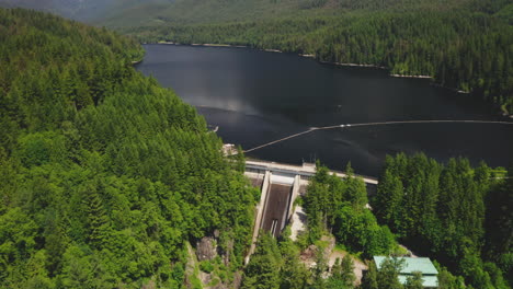 Aerial-view-flying-toward-the-Cleveland-Dam-and-Capilano-Lake-in-North-Vancouver,-British-Columbia