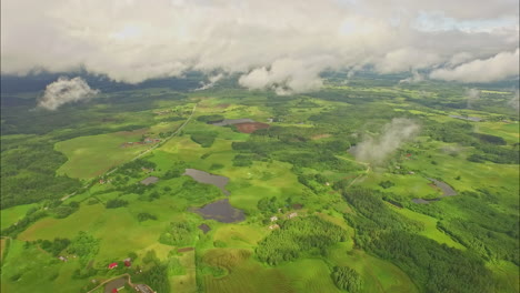 green and vast rural landscape and clouds, high altitude drone view