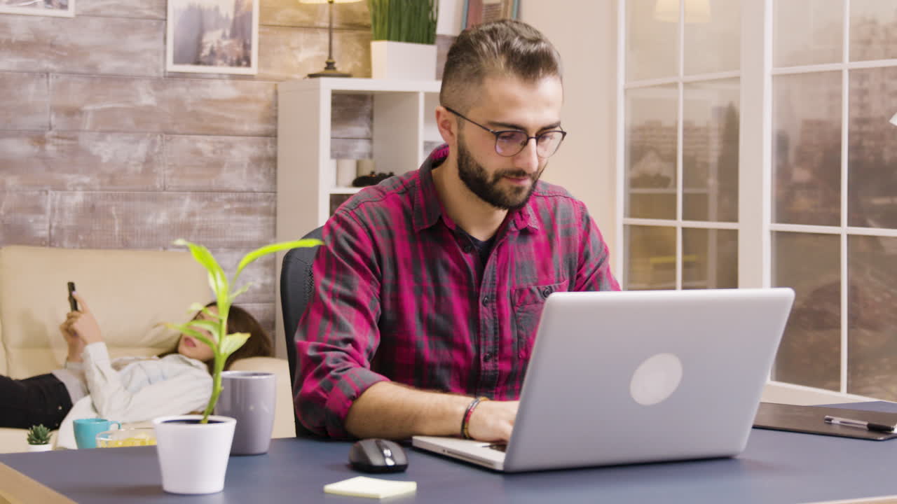 hombre trabajando en una computadora portátil en casa