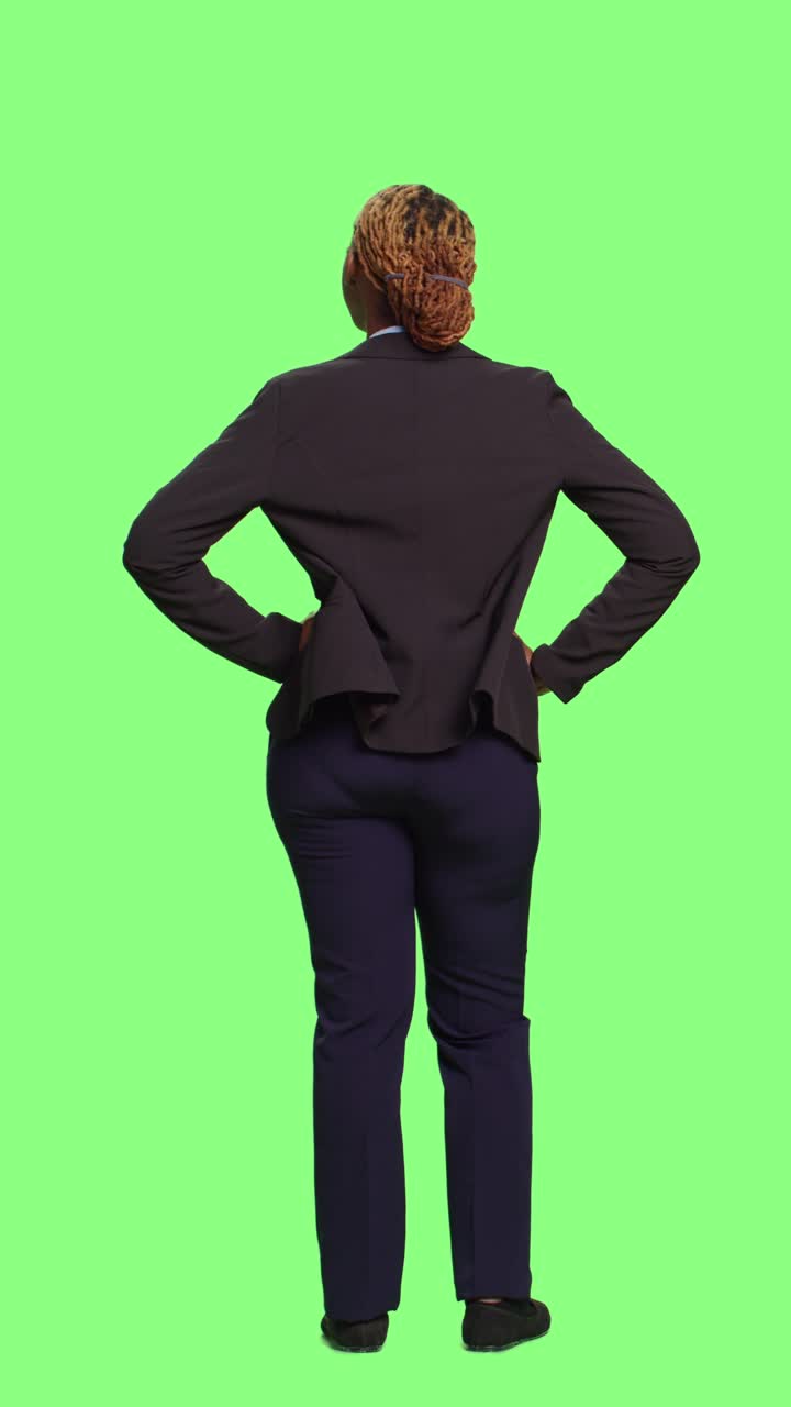 Vidéo verticale : employée de bureau en tailleur faisant la queue sur fond vert