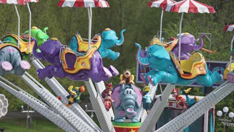 a marry-go-round with elephant-shaped seats in the amusement park