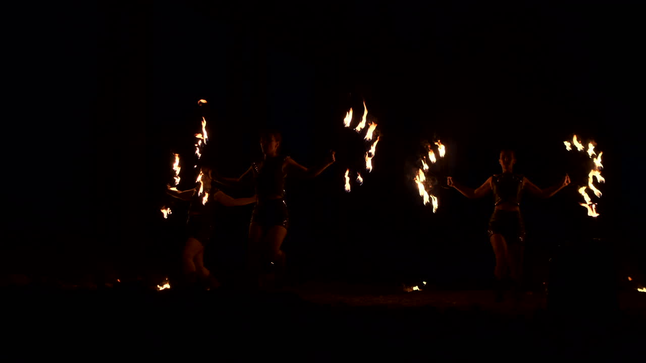 grupo de malabaristas de fuego. la gente escupe fuego en una noche oscura al aire libre.