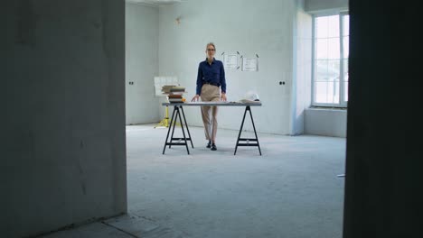arquitecto revisando planos en una casa sin terminar