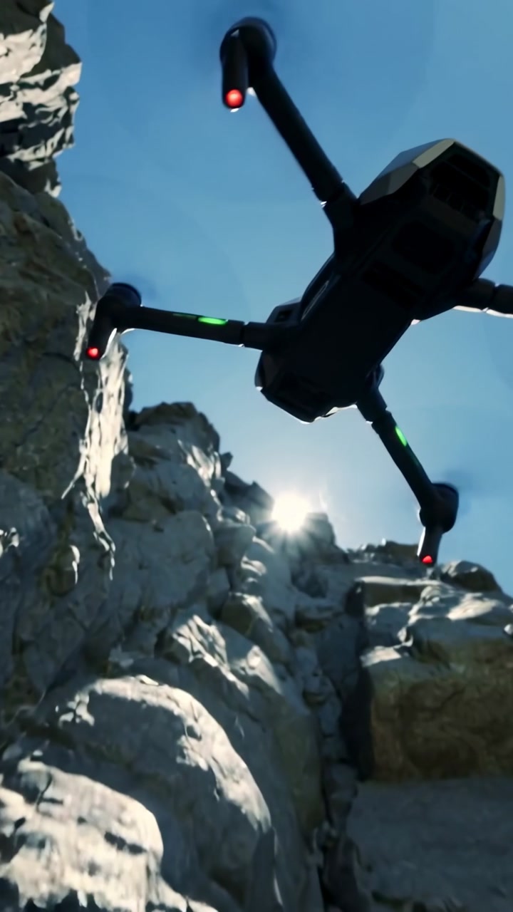 Vertical video: Approaching gap, dark drone banking through cliff to reach sky with red or green LED