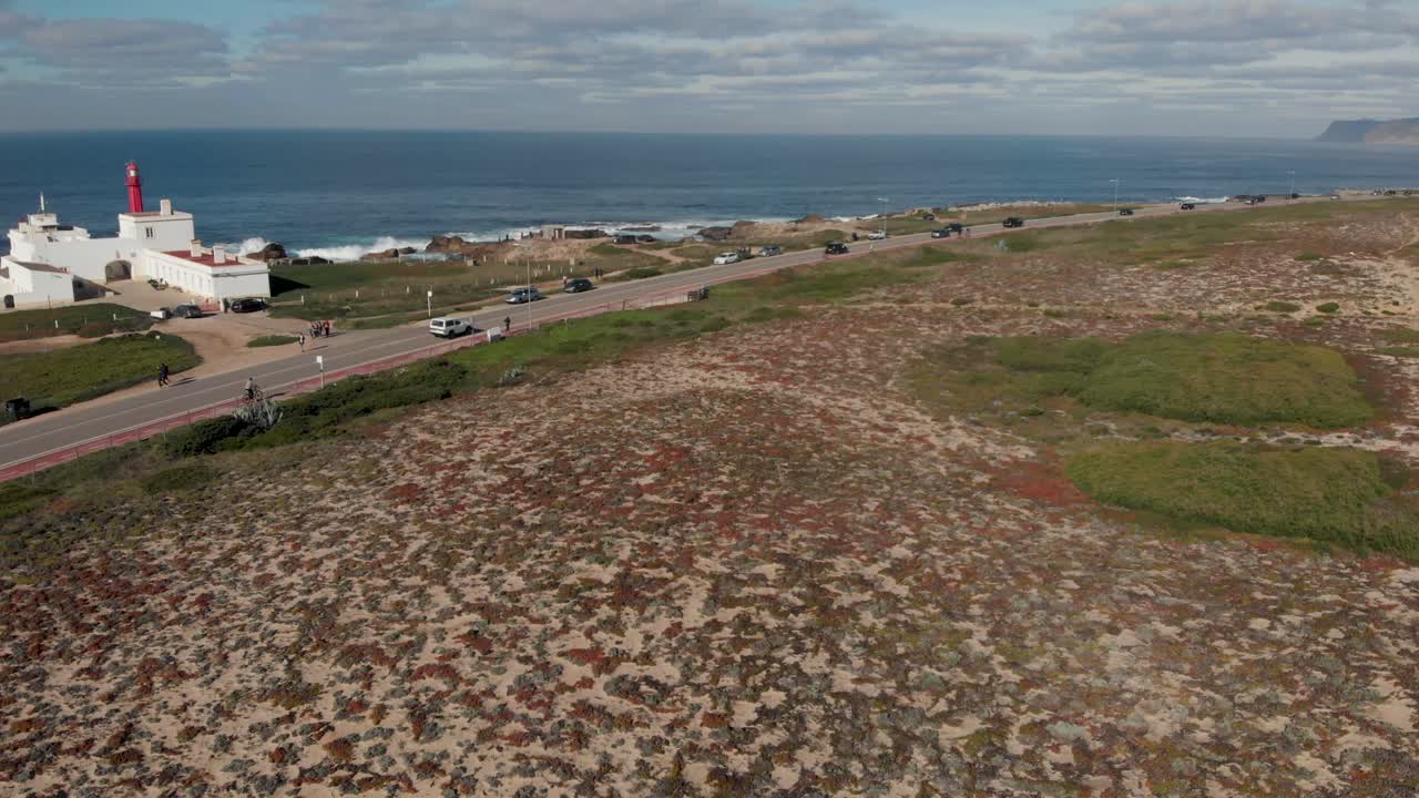 vista aerea de la zona de guincho, con el faro de cabo raso y algunos carros moviéndose sobre marginal