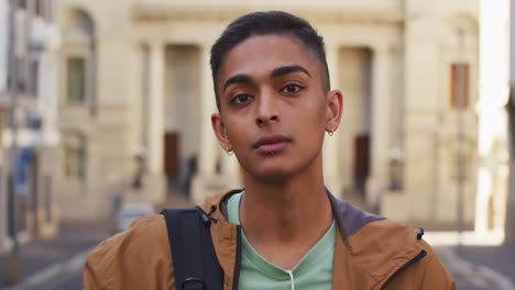 Mixed-race-man-looking-at-camera-and-smiling-in-the-street