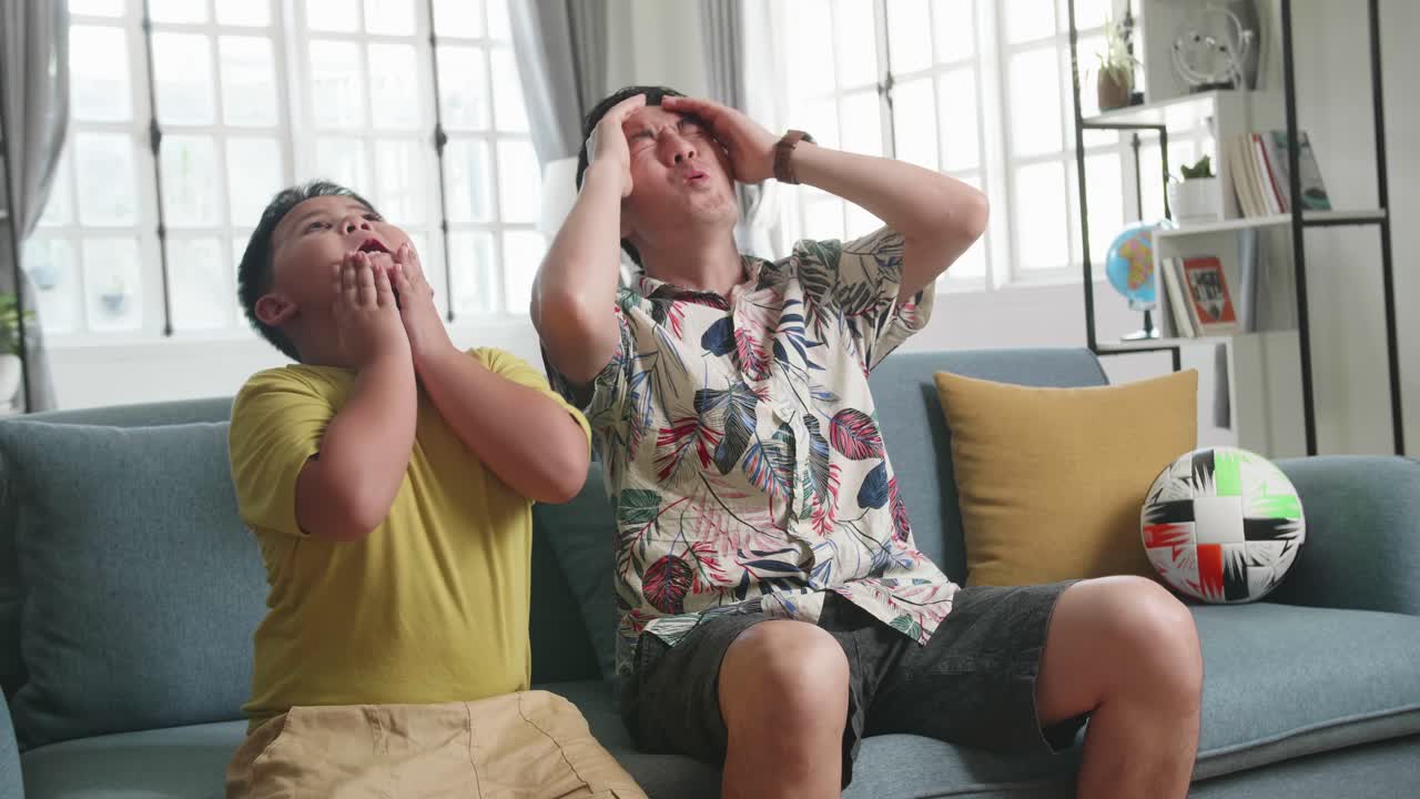 Frustrated Disappointed Asian Father And His Son Are Watching Tv