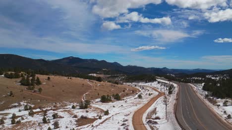 central city parkway black hawk idaho springs gilpin county aerial drone colorado winter snow historic gold mining town road highway blue sky sunny clouds rocky mountains power lines upwards motion