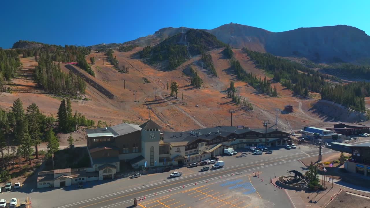 Mammoth Lakes Mountain Ski Area aerial drone California McCoy Station Main lodge Minarets Upper Panorama Gondola summer autumn fall car parking lot sunny blue sky chairlift gondola circle right motion