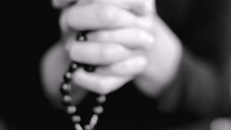 woman praying with hands together with cross on black background with people stock video