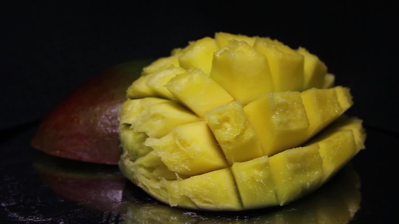 mango en rodajas sobre un fondo negro. metraje de primer plano