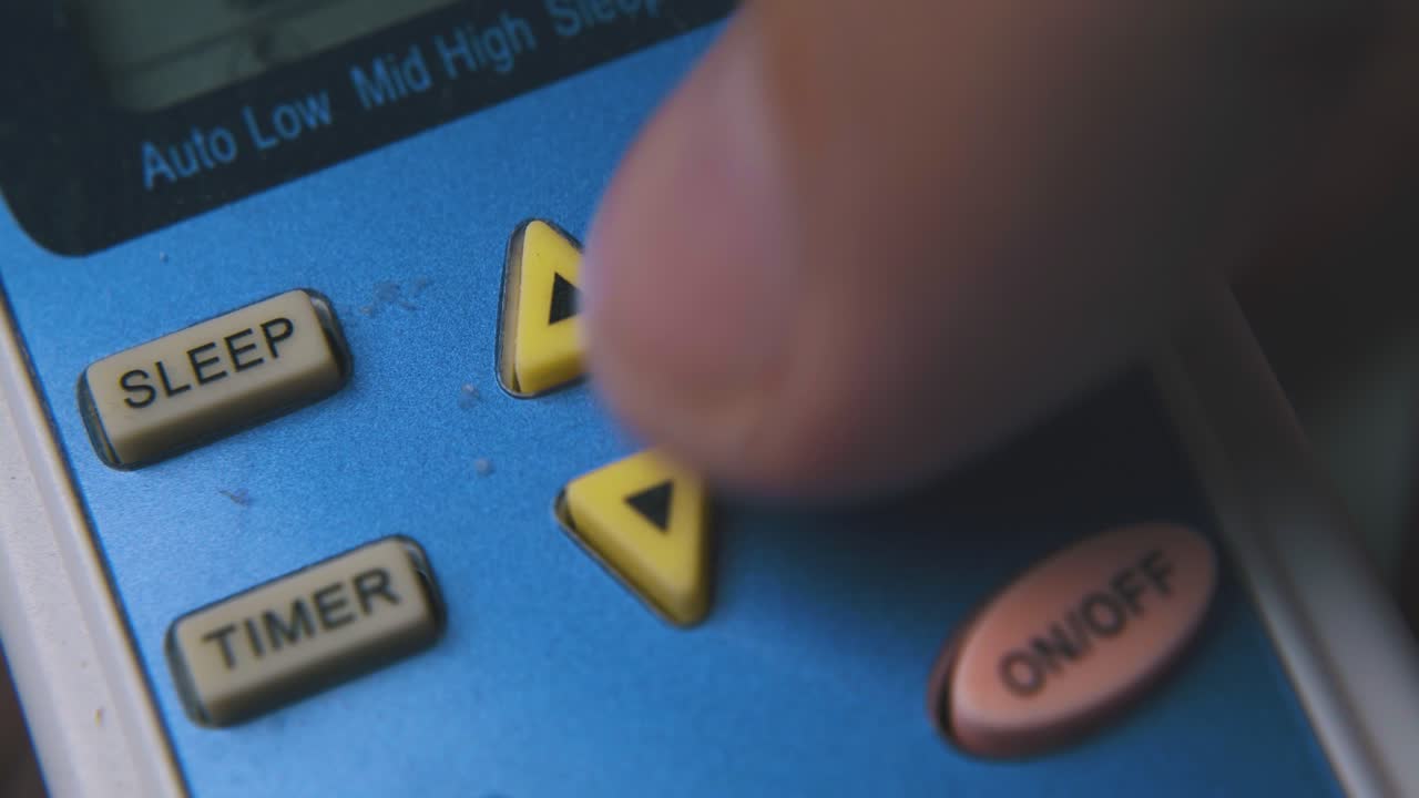 el hombre cambia los modos del acondicionador de aire con el controlador macro