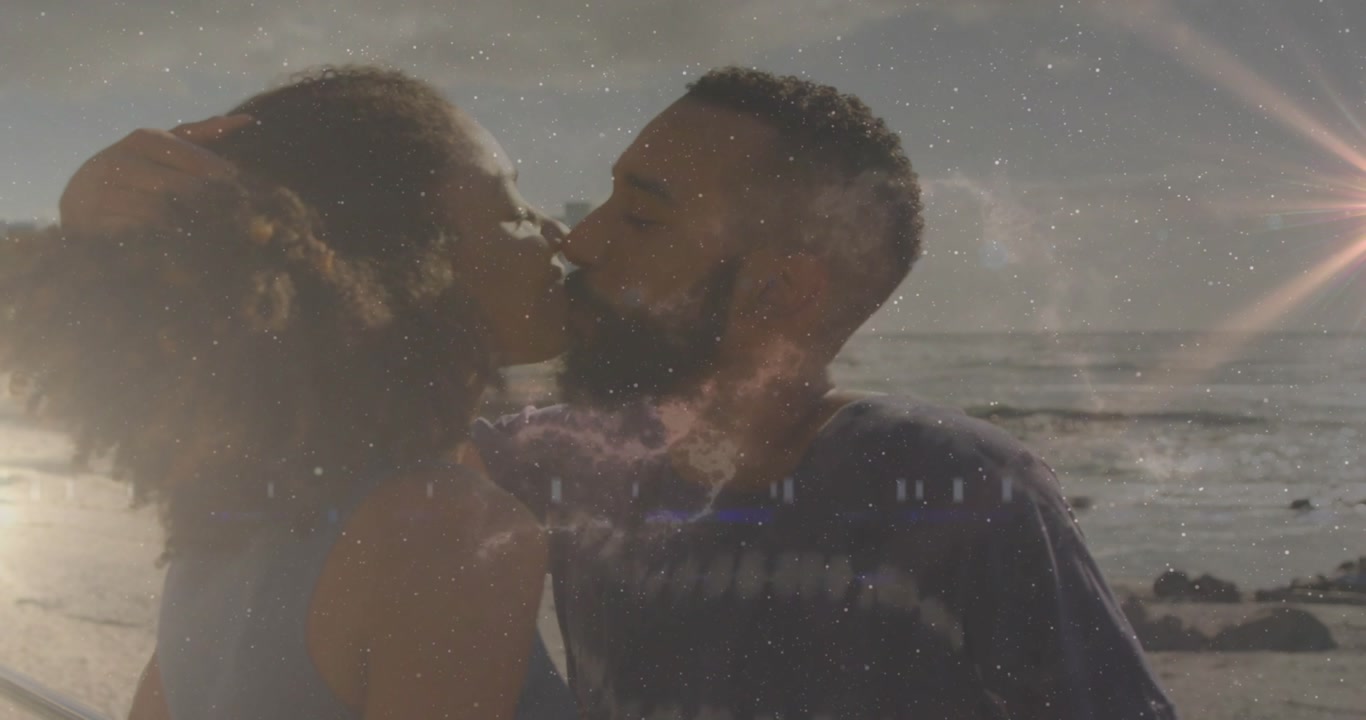 Vertical video: Man raising hand tucking woman's hair, kissing on beach, ad showing romance and st