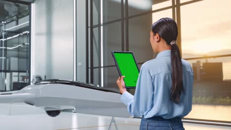 mujer usando una tableta en una oficina moderna con un dron