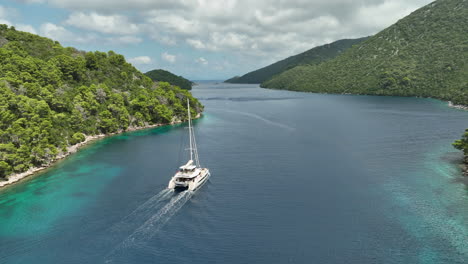 big catamaran sails out of the mljetski canal on a sunny day