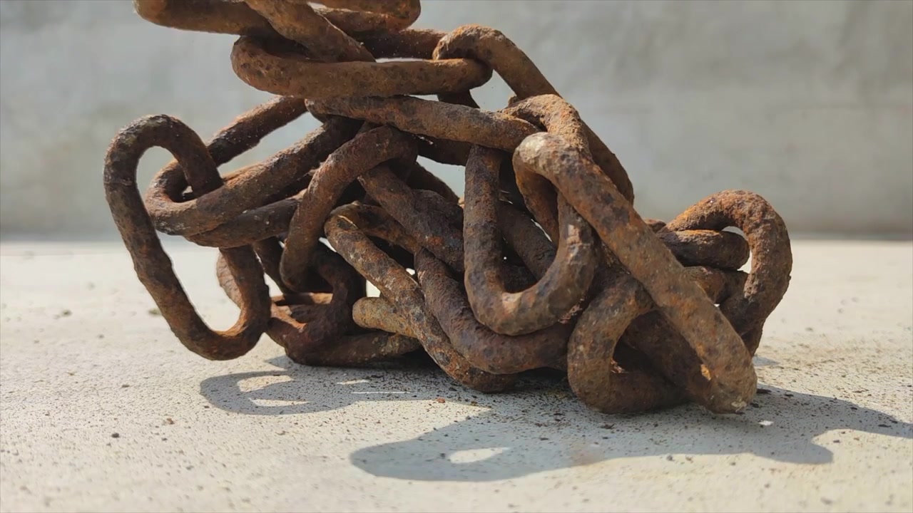Rusty Metal Chain Falling and Piling on Concrete Surface