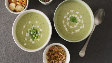 Video-Von-Grüner-Erbsensuppe-Und-Zutaten,-Die-Auf-Einer-Grauen-Oberfläche-Liegen