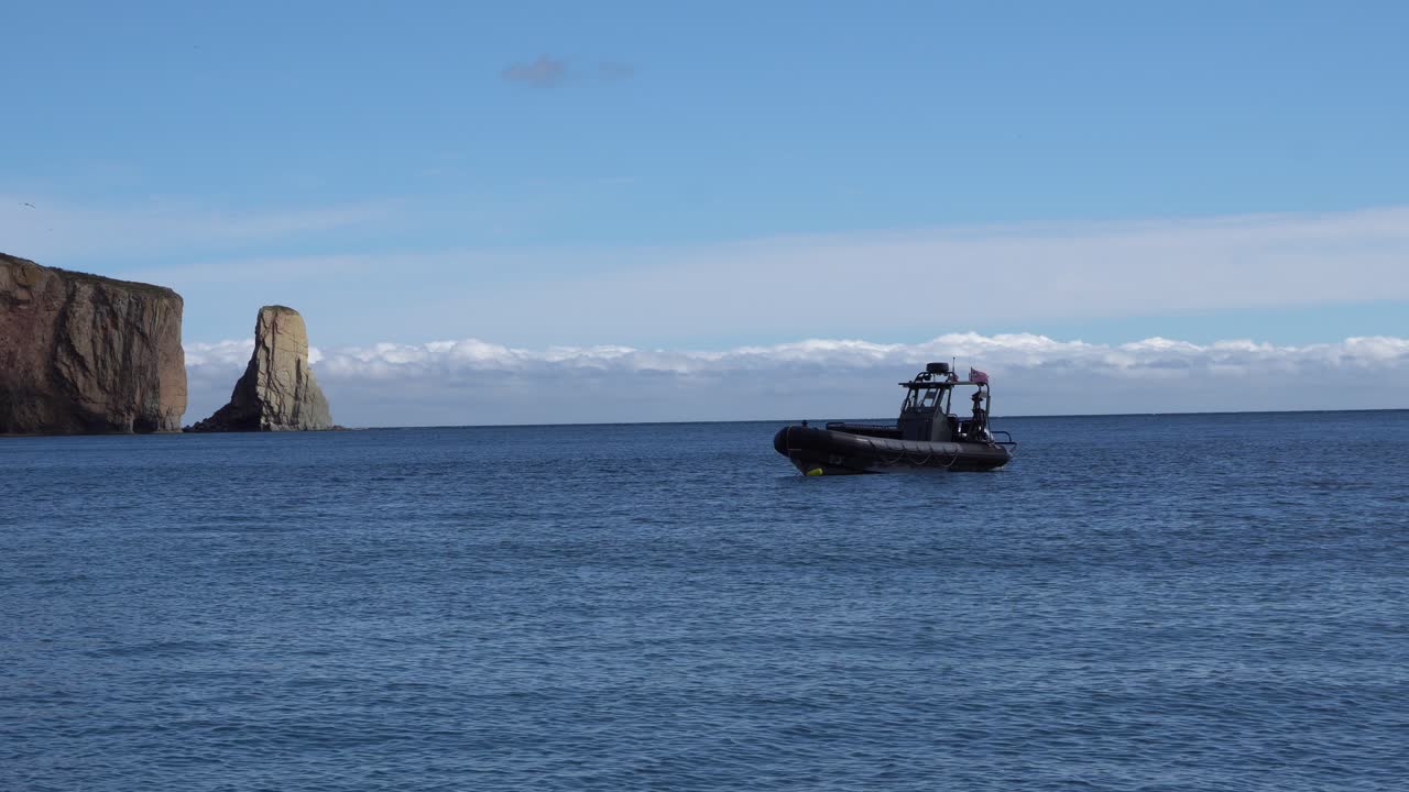 un barco negro en espera solo en el mar que se mueve bajo el efecto de las olas