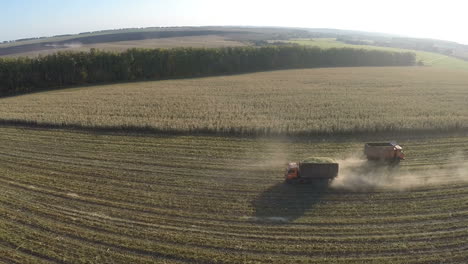 Trucks-driving-in-the-field-aerial-view