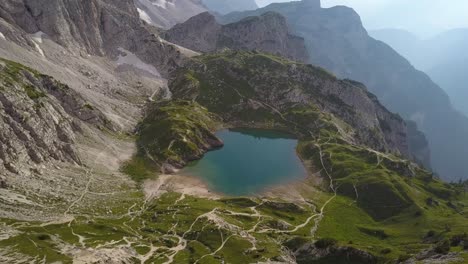 aerial of a oasis like pond in the mountains in dolomites in italy, lake coldai, alleghe, dolomites