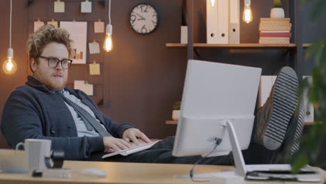 man relaxing at work with feet up