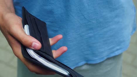 a man looks at a wallet full of banknotes 01