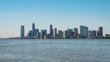 STATIC-TIME-LAPSE:-In-New-York-City-looking-across-Hudson-River-towards-Jersey-City-and-Hoboken-with-Statue-of-Liberty-in-background