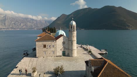 orbiting aerial shot reveals our lady of the rocks in montenegro