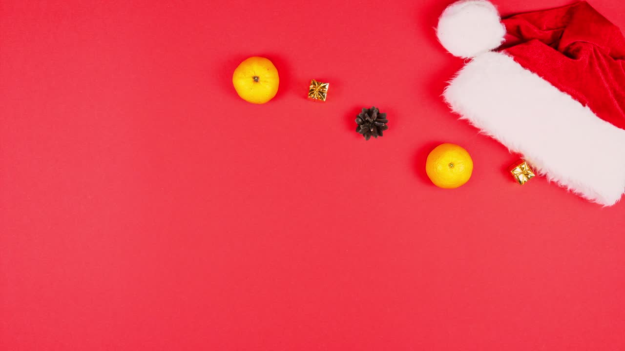 animación de stop motion de regalo de año nuevo, mandarina, cono de árbol y sombrero de papá noel. capa plana de decoración de navidad y sombreiro rojo