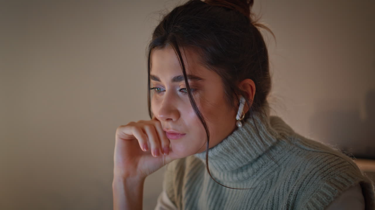 mujer enfocada en primer plano trabajando atentamente mirando la pantalla de la computadora portátil en la noche de casa