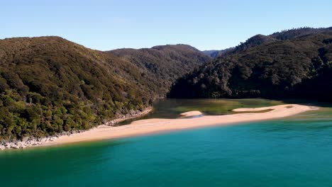 pequeña playa de arena a través de la bahía de sandfly vuelo aéreo tiro hacia atrás