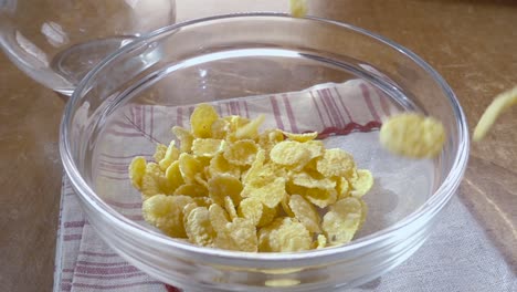 flocos de maíz amarillos crujientes en el cuenco para la mañana un delicioso desayuno con leche. cámara lenta con toma de seguimiento de rotación.