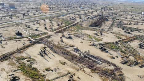 pumping crude oil at oil wells in the fields for high demand fossil fuels - aerial flyover