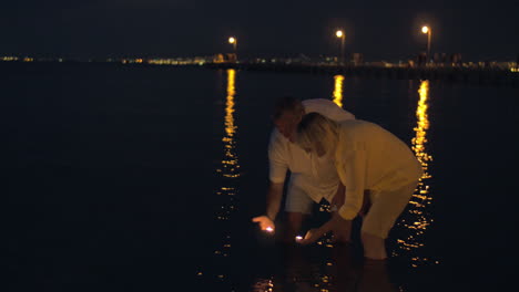 Pareja-Madura,-Hacer,-Velas,-Flotar,-En,-Mar,-Por-La-Noche