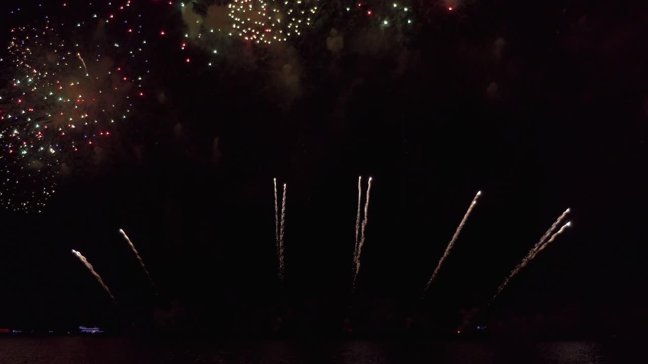 increíble espectáculo de fuegos artificiales de colores sobre el mar en la noche de celebración