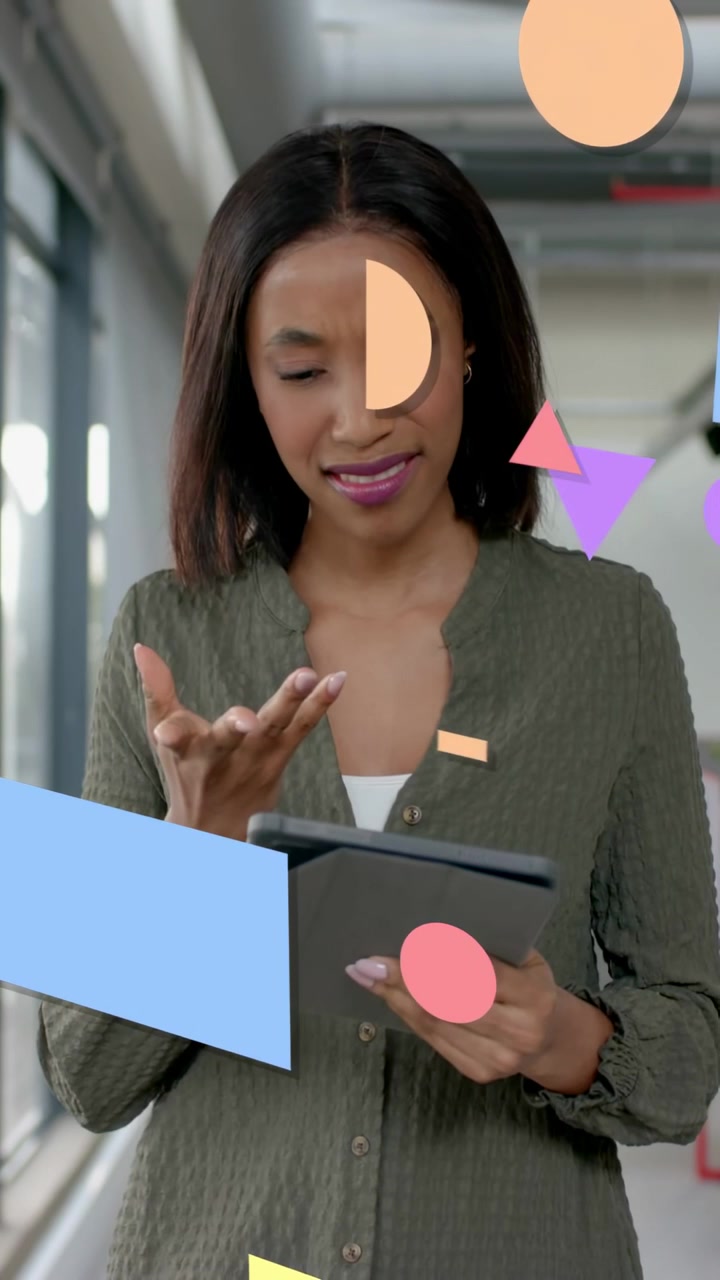 Vertical video: Woman tapping tablet for UI in tech hall starting geometric shapes moving over her