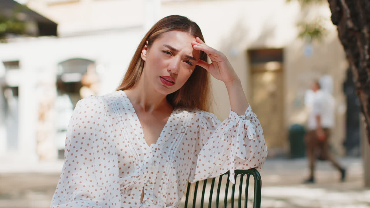 mujer frotando el templo para curar el problema del dolor de cabeza sufriendo de tensión migraña estrés en la calle de la ciudad