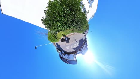 little tiny planet 360 small world view of a man walking past large white building in 4k