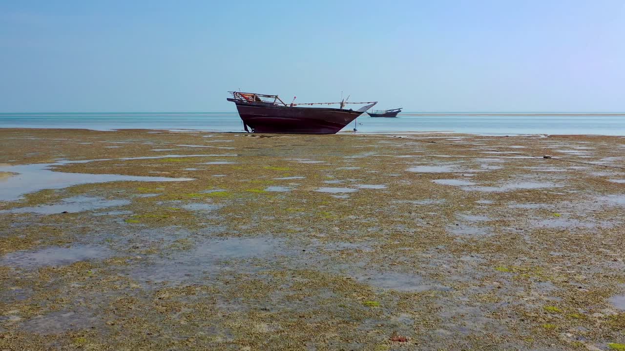 Drone fly toward boat stand on beach in Oman, aerial tracking