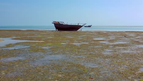 drone fly toward boat stand on beach in oman, aerial tracking