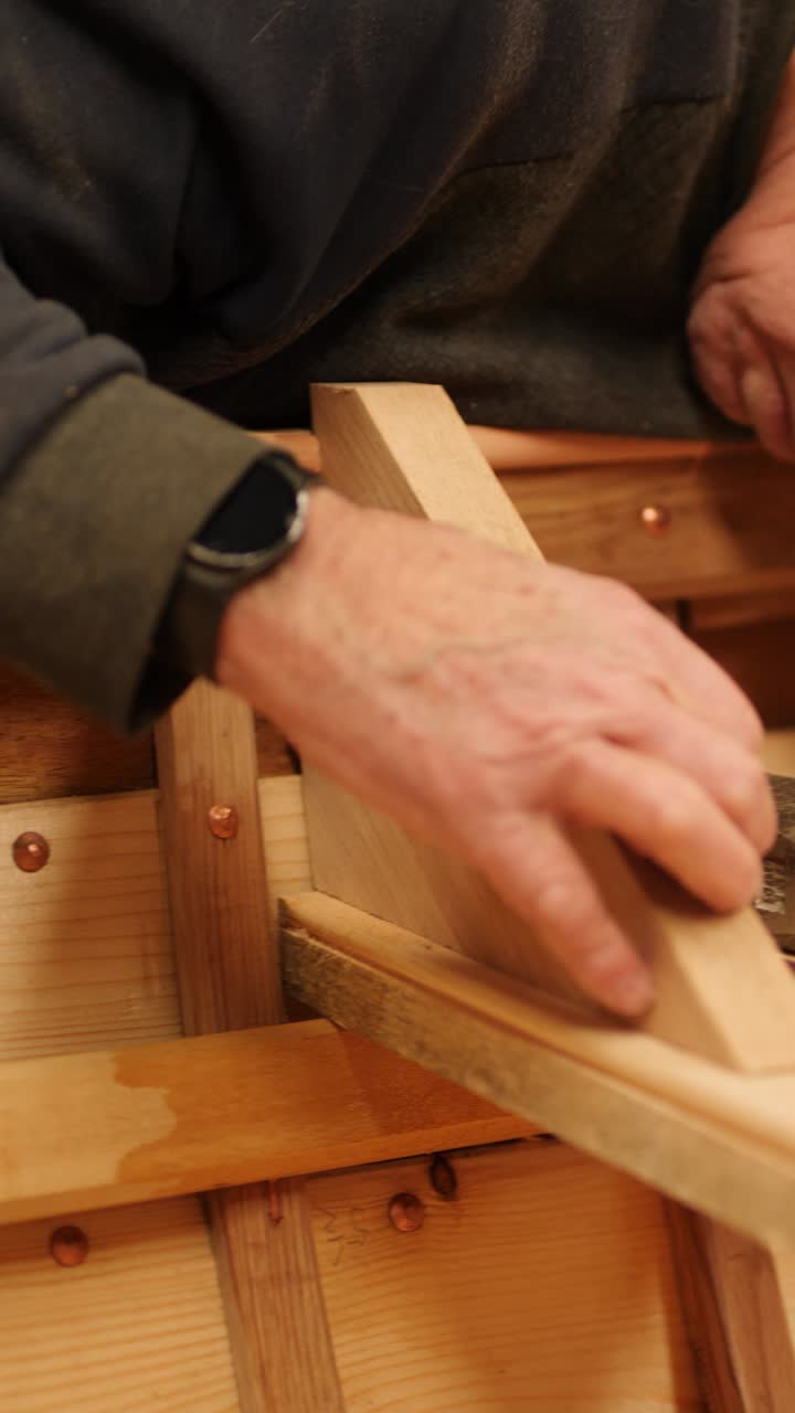 Boatbuilder hammers oak knee into position