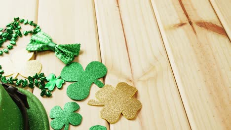 Video-of-st-patrick's-green-hat,-shamrock-and-bow-tie-on-wooden-background